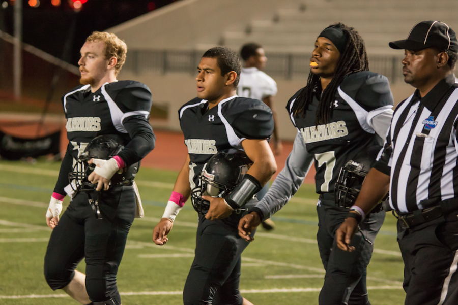 Warrior captains Robert Wooten, Alex Figueroa and Selah Morgan take to the field for the coin toss against Forsyth Central.