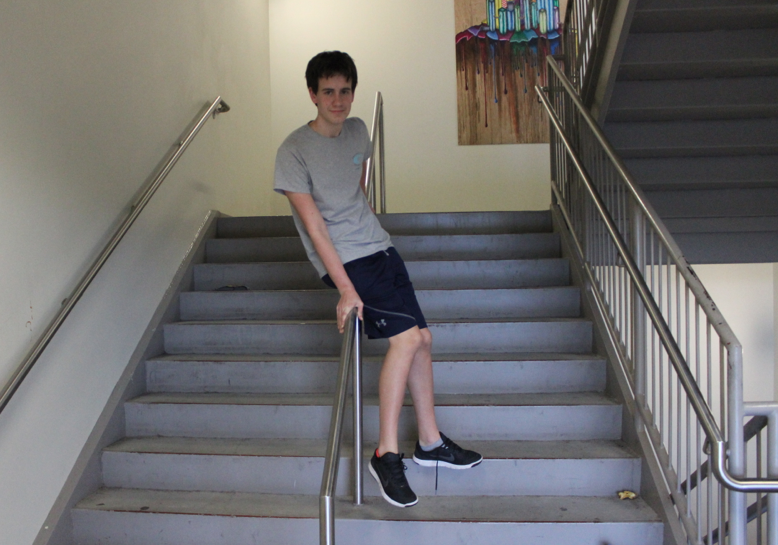 Freshman editorial writer, Jack Yanoshik, slides down a banister in the colossal 11 story North Atlanta school building. 