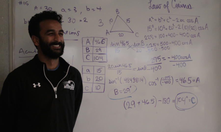 Math+teacher+Hemal+Patel+poses+in+front+of+the+intricate+work+he+displays+on+the+board+for+his+students.+