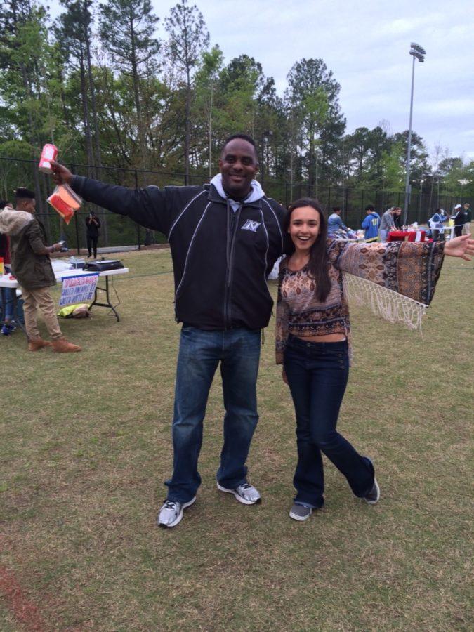 Film festival planner Paige Overmyer celebrates the big success with Principal Douglass on the practice field. 