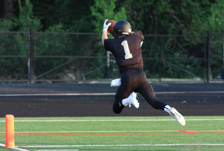 Captain Jack Ferguson dives across the line to score a touch down for the Warriors at the home scrimmage against Holy Innocents. 