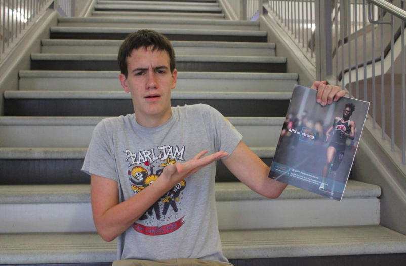 Editorial writer Jack Yanoshik poses with the  the APS student handbook and some questioning glances. 