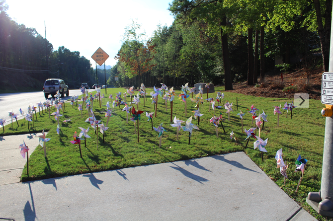 Northside Parkway commuters catch a glimpse at the array of colorful pinwheels scattered across North Atlantas front lawn. 