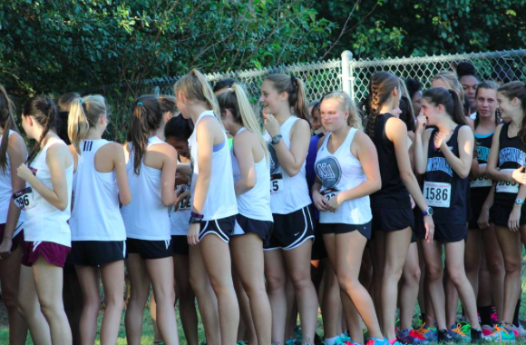 The girls cross country team waits patiently to start running. 