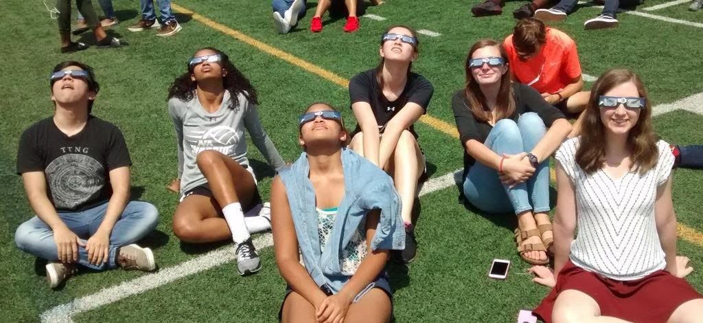 Students safely view the solar eclipse with designated glasses