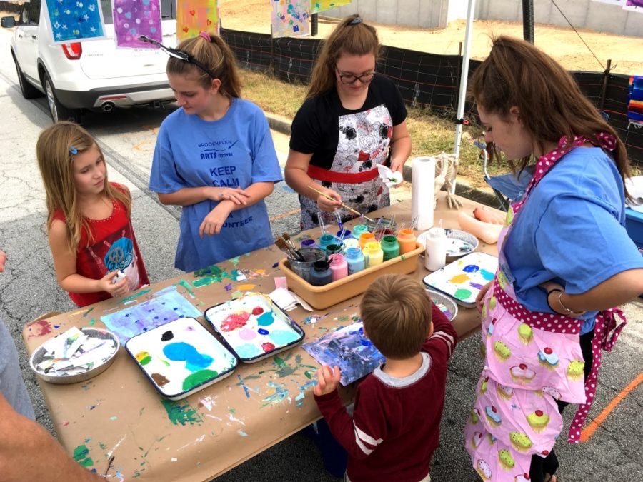 National Art Honor Society members senior Anna Day, junior Matilda Redfern and senior Ava Daughters help young art enthusiasts enjoy their day at the Brookhaven Art Festival. 
