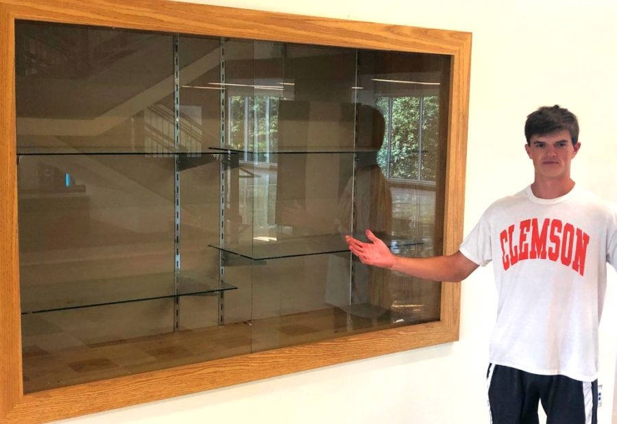 Sanction Setback: Junior Wiley Hartley, varsity football starting quarterback, stands next to an empty trophy case, perhaps a symbol of the recent sanction school athletics absorbed because of an ineligible basketball player. 
