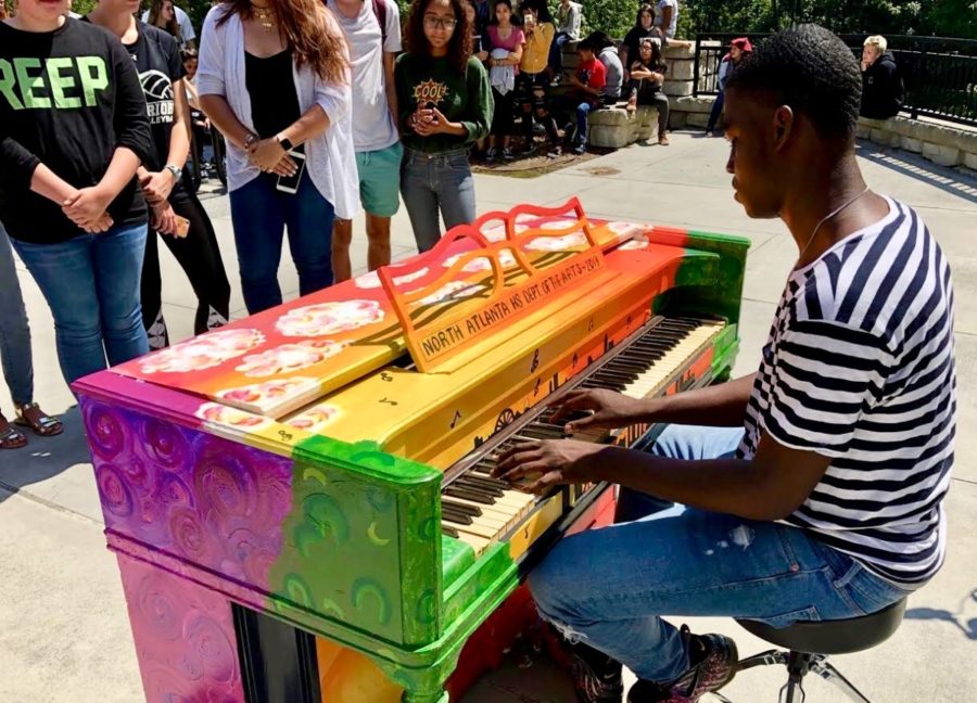 Playing With Paint: Senior Christopher Robinson performs on the piano for the Pianos for Peace project.