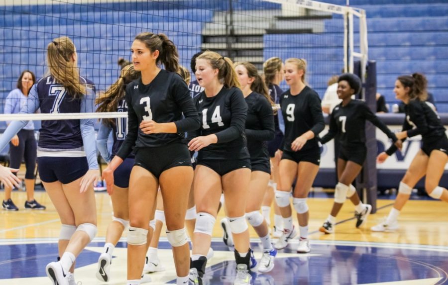 Courting Glory: Senior Savannah Denton leads the Warrior Volleyball team on to the court during a match this season against Lovett.