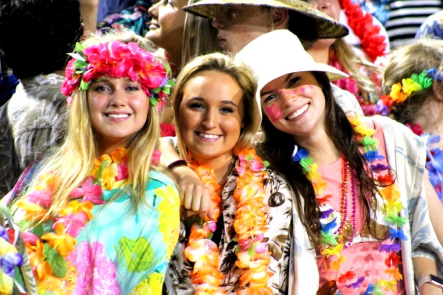 Beach Party Theme: Seniors Hanna Shaw, Annalie Chesin and Addie Derrick were part of the Warrzone crowd during the Warriors Sept. 21 victory over Cambridge. The Warrzone, organized by the North Atlanta Spirit Club, has kept spirits bright during Dub football games this fall. 