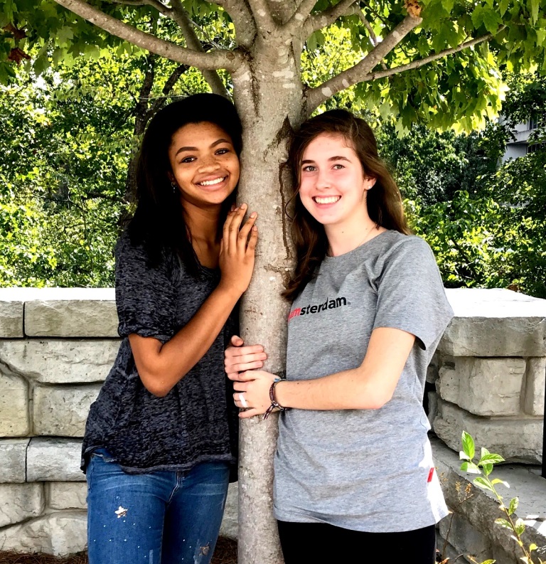 Tree Huggers: Junior Soleil Golden and sophomore Caitlin Hohenstein plant the seed of promoting the environment by helping to keep the school clean and green.

