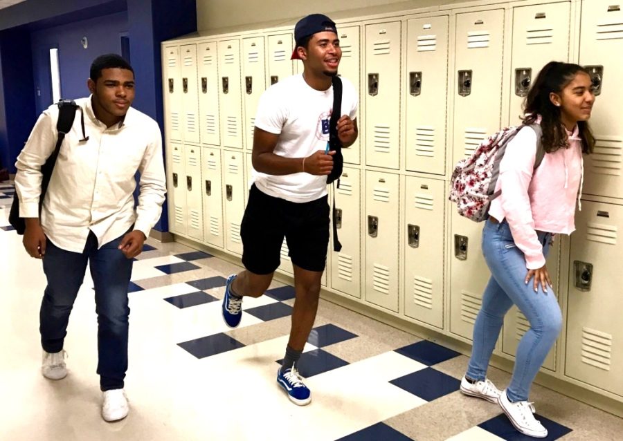 Too Little Too Late: Junior Yasiah Jamison, senior Joshua Johnson and junior Giannys Roman race to class in order to avoid the weight of the new tardy policy bearing down upon them.