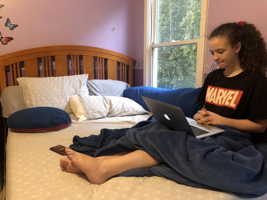 Cozy in Class: Junior Maddie Krachon snuggles up in bed as she logs into her virtual classes.