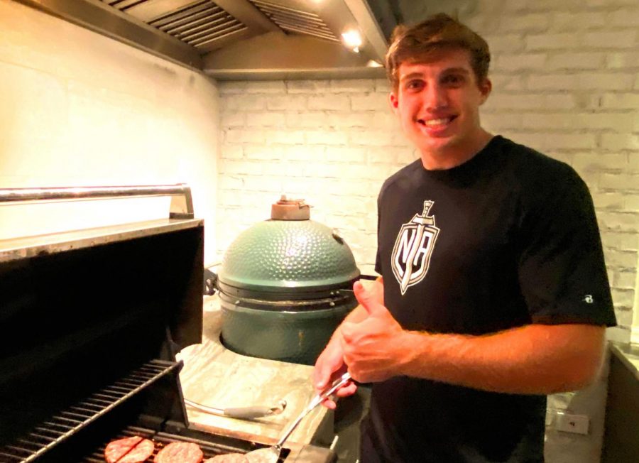 Lunch Is Served: Senior Ned Coleman is one of many Warriors is making the most out of extended time for lunch owing to a home-based COVID schedule. Coleman, shown here grilling a large shank of meat, said he frequently grills for the mid-day repast. 

