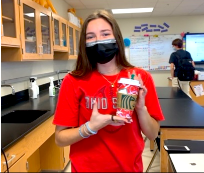 Delicious Drinks: Junior Gabby McHaffrey poses in between sips of her tasty holiday Starbucks drink. As the holidays near, drink and food joints across the city add seasonal items back to menus for all to enjoy.