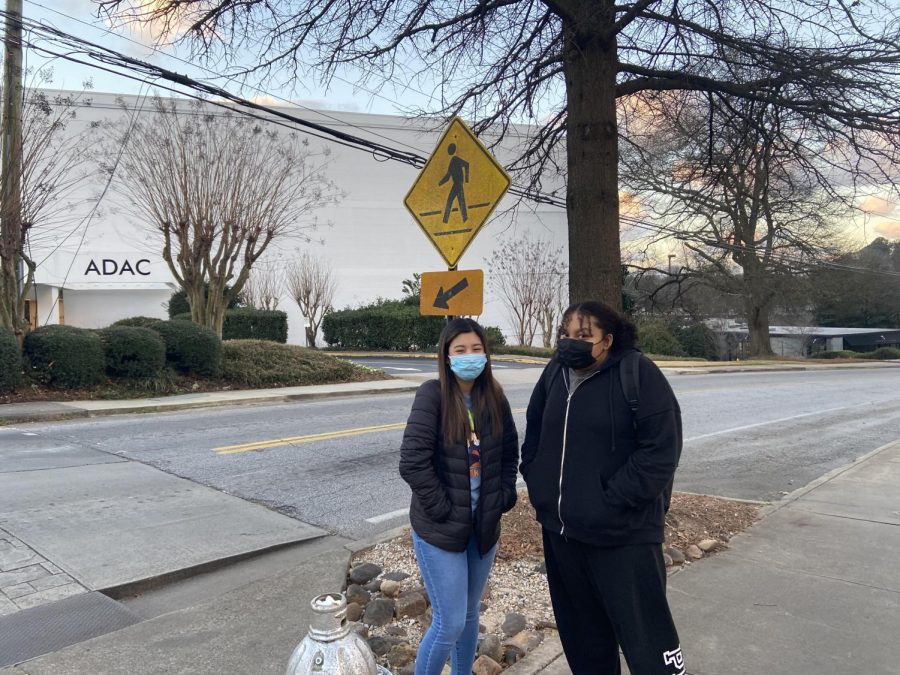Morning Shiver: North Atlanta senior Grecia Pino and freshman Eleni Phillips brave the cold as they await a wintertime bus ride to school.