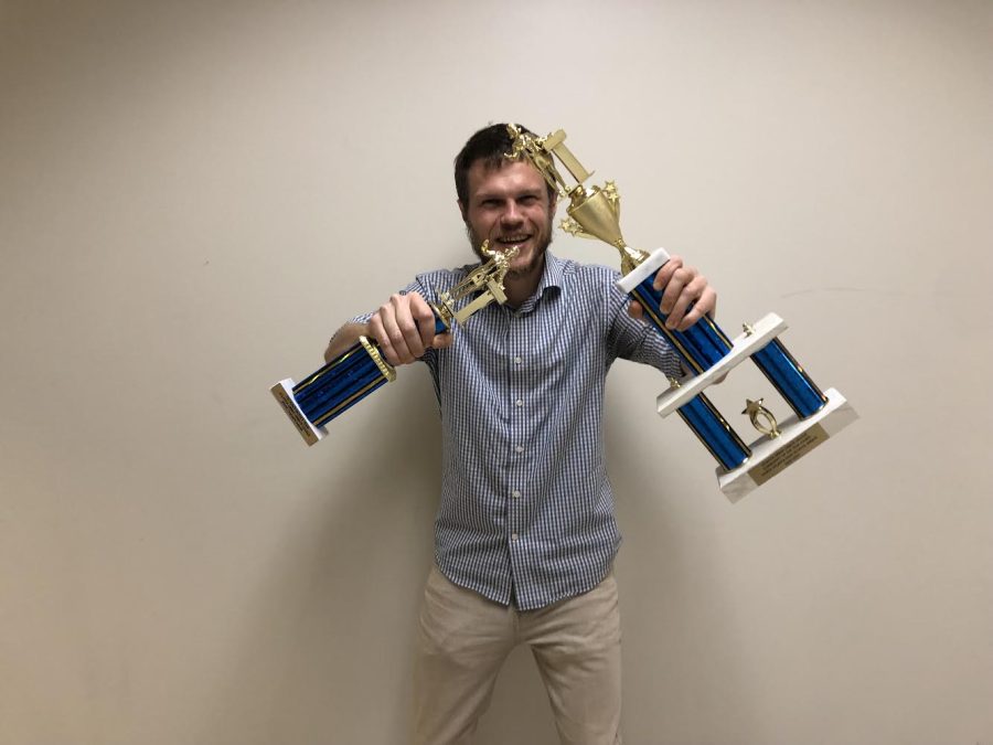 Dubs in Debate: Distinguished history teacher and Speech and Debate coach Mike Robinson poses proudly with well-earned team awards.
