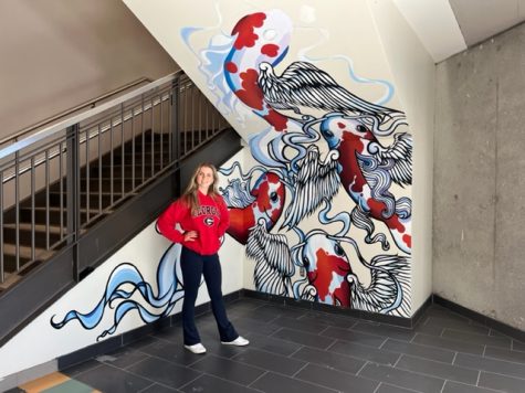 Stellar Student: Senior Anna Rohn shows off her newly painted mural in the atrium.