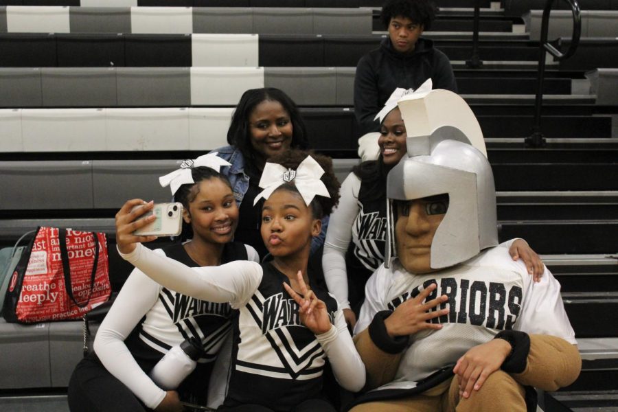 Squad Spirit on Fire: Juniors Charity Dent and Willow Gibbs, sophomore Kyndall Weathers, Coach Jennifer Page, and Maximus The Warrior flash a pose to celebrate their North Atlanta pride.