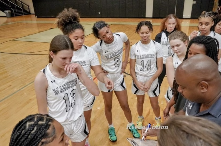 In+the+Huddle%3A+The+girls+are+taking+in+coachs+game+plan+during+a+timeout.+