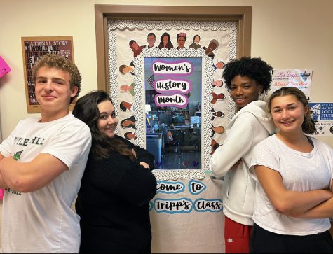 Better Together: Sophomores Rigsby Gullett, Sofie Golomb, Jacoby Barber and AP World History teacher Caitlin Tripp stand side-by-side next to Tripps Womens History Month door display.