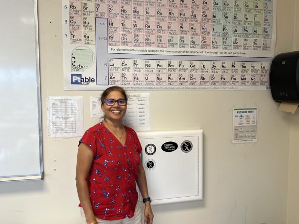 All Smiles: Aruna Kailasa stands proudly in front of her most prized possession - the periodic table!