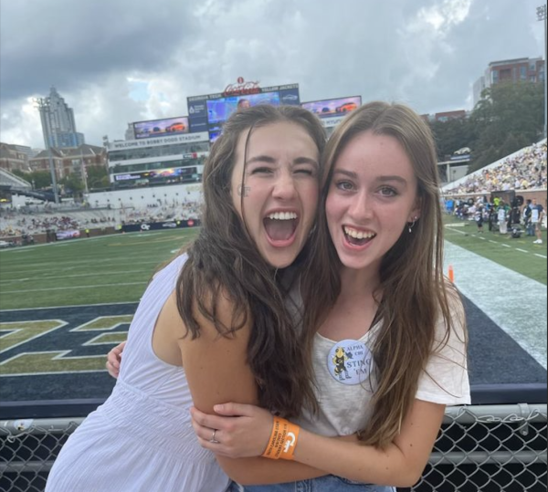 Caption: Sophie Haines and Zeynup Law, both NAHS 2023 grads, take a break from studying with a Georgia Tech football game.