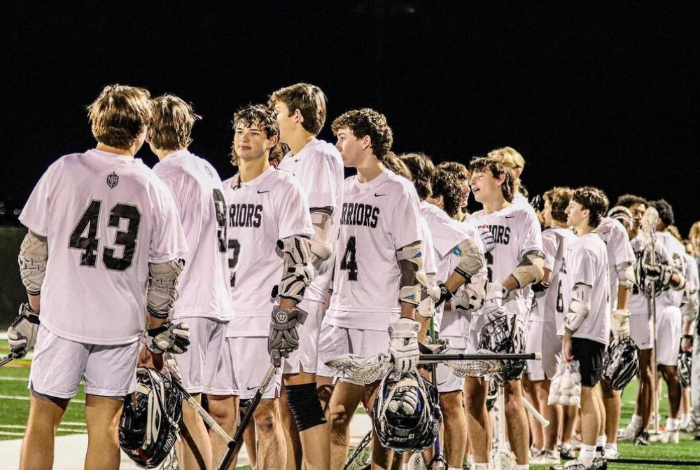 NAHS Lax Begins: boys lacrosse crowds the sideline