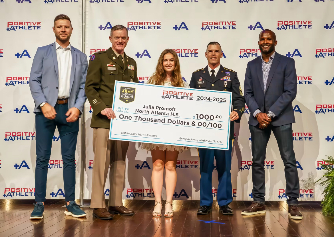 Bryan Cole (left), Champ Bailey (right) and two representative from the US Army present Julia Promoff with a check