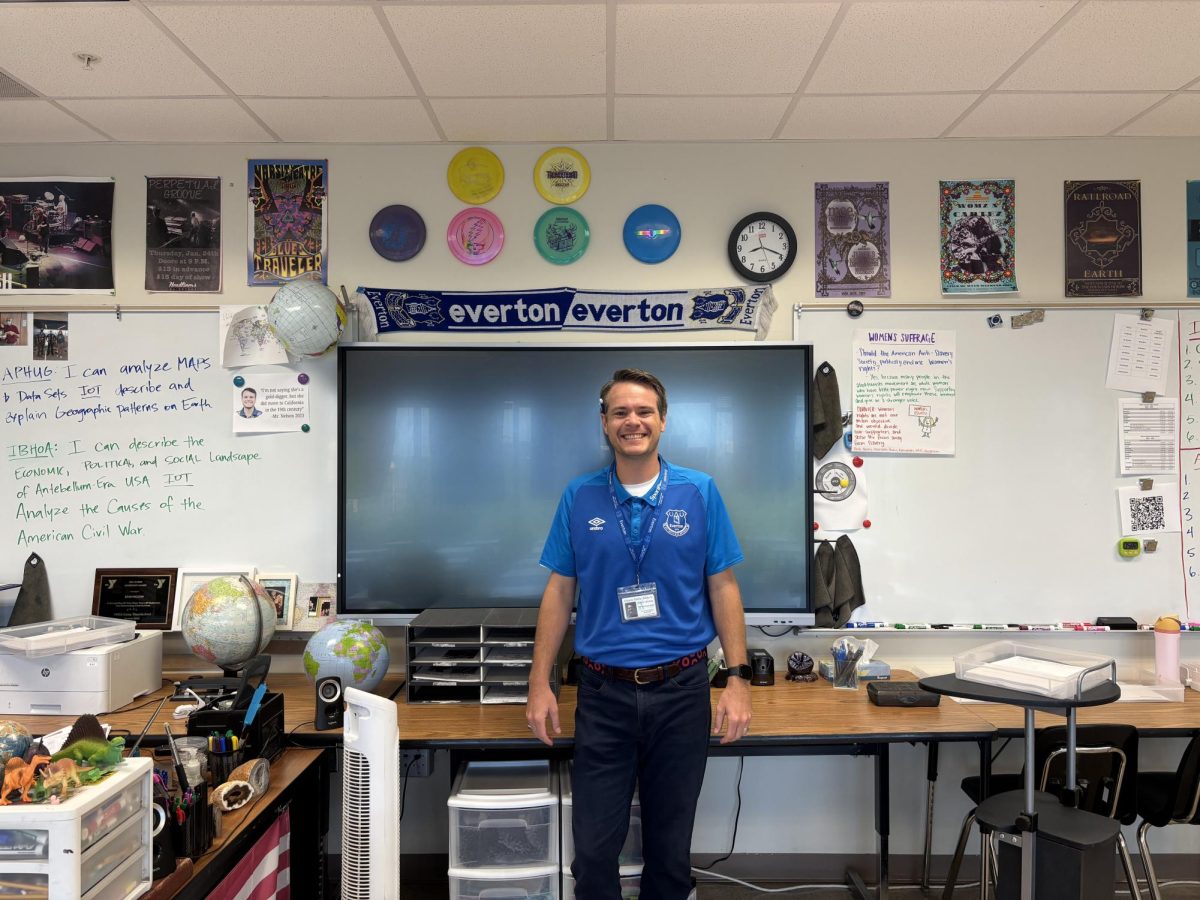 Mr. Nelson standing under his prized weapons.
