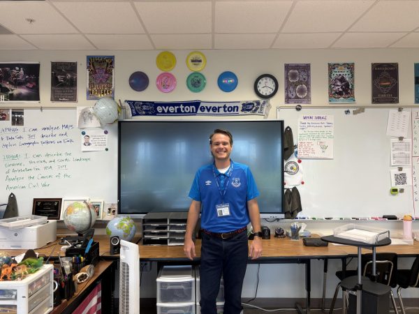 Mr. Nelson standing under his prized weapons.