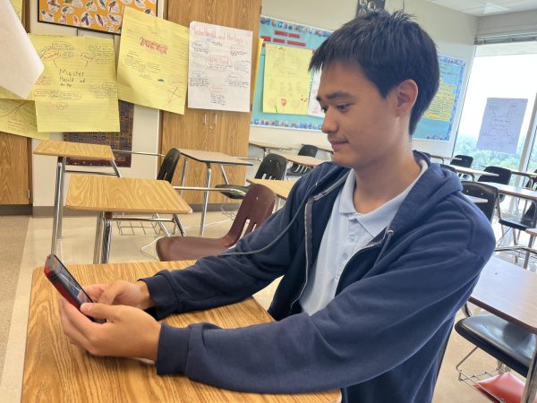  Junior Andrew Oftedahl hangs onto his phone for a few final seconds before relinquishing it to the phone jail.