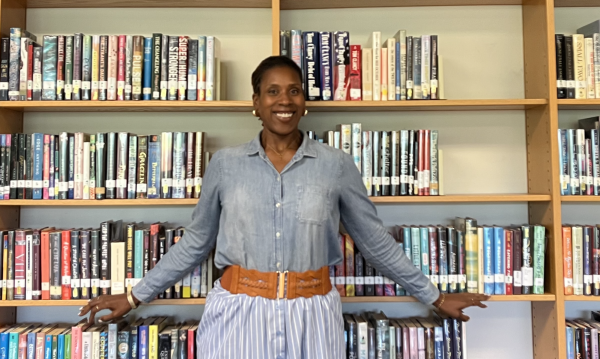 Coston Poses in front of book shelves in the media center