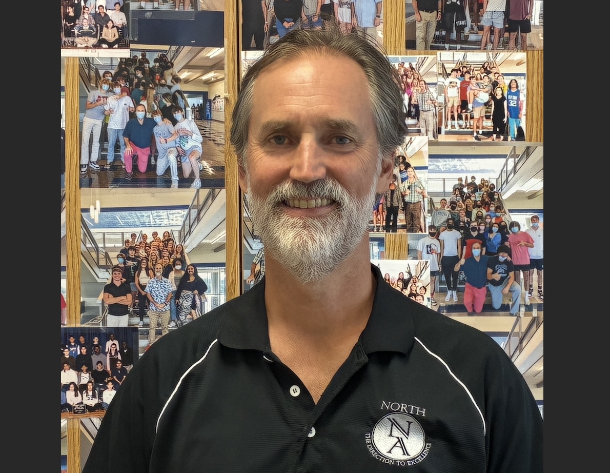 On Senor William's door are photographs of his classes dating back to his earliest years. Above: Senor posing before his famous picture cabinet.