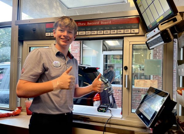 Sophomore Jean-Luc Khayat is all-smiles while working the Chick Fil A drive-through alongside sophomore Walker Jackson. (pictured in the back)