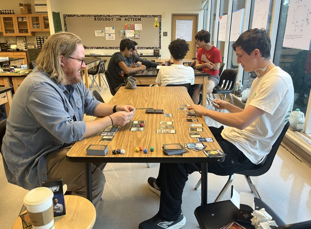 Advisor Robert Bennet and club member Gabriel Welty compete in an intense round of Magic.
